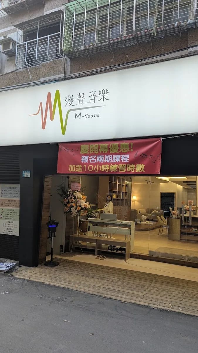 漫聲音樂店面側面，白色招牌與慶開幕紅布條，落地窗透出溫暖燈光