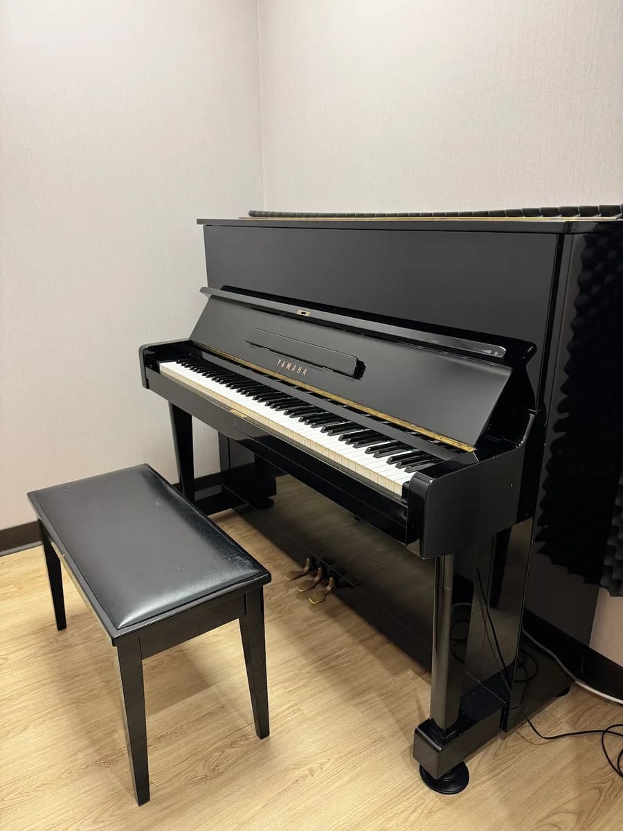 YAMAHA 直立式鋼琴獨立琴房，白牆、隔音棉與淺木地板